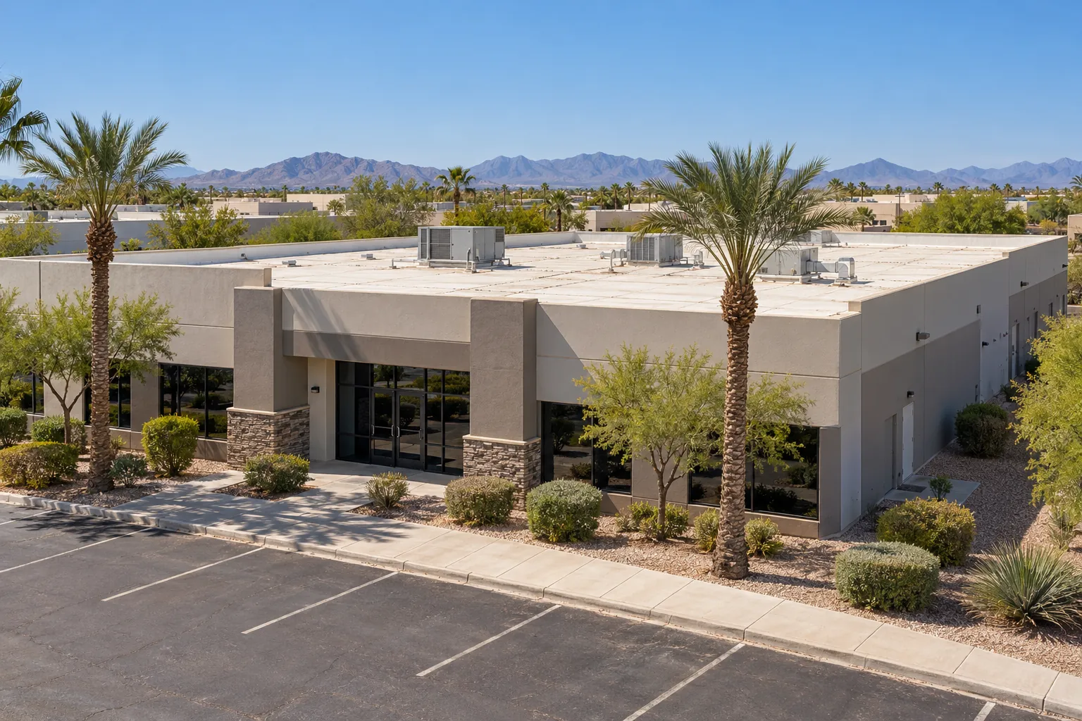Single-story office and flex building with an aged white membrane roof