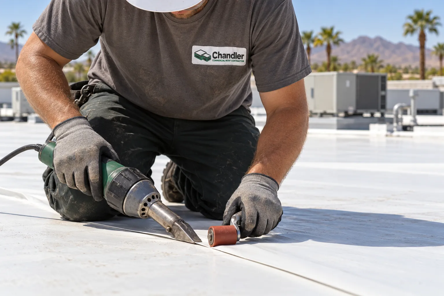 Gloved hands rolling a hot-air welded TPO seam